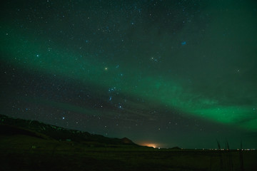 Fototapeta na wymiar Northern Lights in cold Icelandic nights, near waterfall Seljalandsfoss