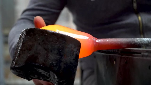 shaping molten glass vase on a rod