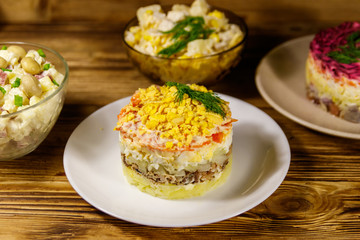 Set of festive mayonnaise salads on wooden table