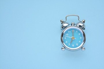 Retro alarm clock on light blue background, free space for text, good morning concept.