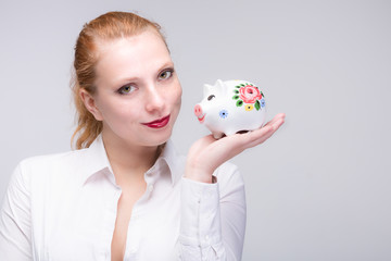 young red haired woman with her piggy bank