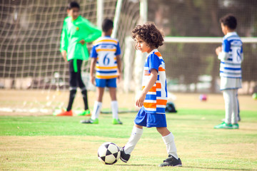 Little boy plays football outdoor. Children and lifestyle concept
