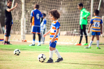 Little boy plays football outdoor. Children and lifestyle concept