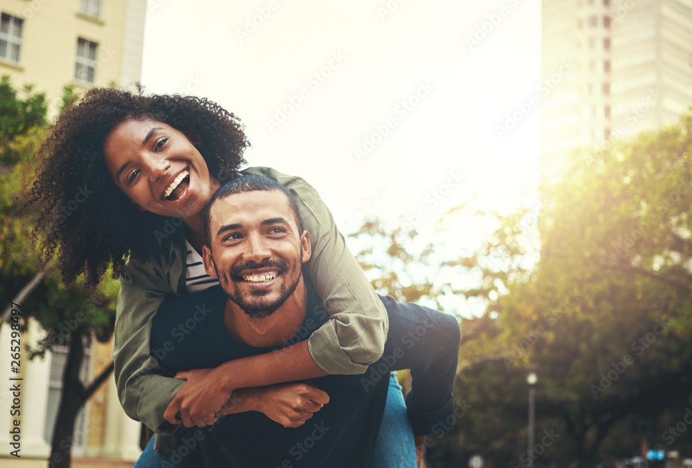 Wall mural Man giving piggyback ride to woman