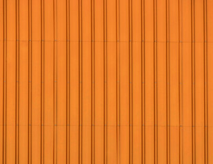 Beautiful background stainless steel corrugated sheet closeup with brushed textures in orange color