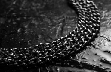 Shiny metal chains on stone background
