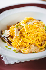Homemade Italian tagliatelle with mushroom sauce in a white plate