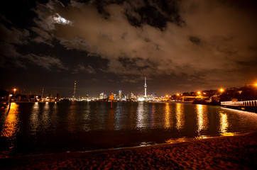 Auckland City and Sky Tower from beach at Night