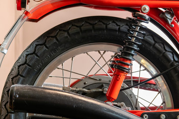 Obraz premium Close up of seat, exhaust, rear wheel and suspension of a red vintage motor bike