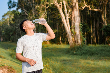 Young man drinking water after running