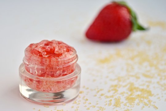 Homemade fresh strawberry lip scrub with brown sugar, natural cosmetics, close up view.