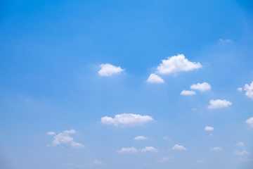 Fuffy clouds on bright blue sky background.