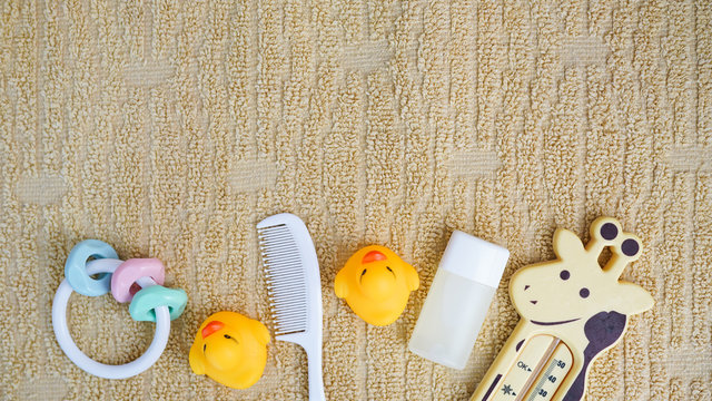 Baby accessories for bathing and toy on towel with copy space, flat lay