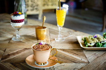 Capuccino with sweet on a Wood table