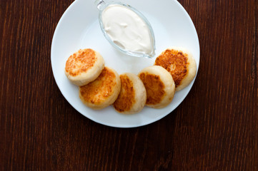Fried cheesecakes with sour cream top view, with place for text. For cafe or restaurant menu design.
