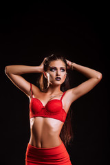 Fototapeta premium Brunette in red suit posing in the studio