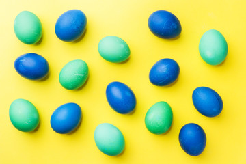 Colorful Easter eggs on yellow background. Copy space.