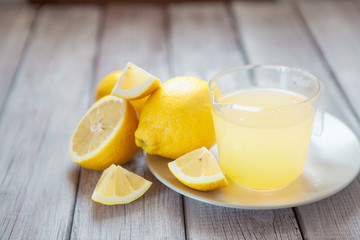 Freshly squeezed lemon juice on wooden table, copy space