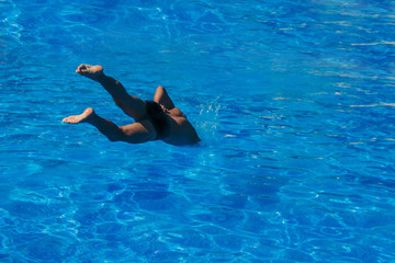 a man jumps into the pool. Swimmer in the water
