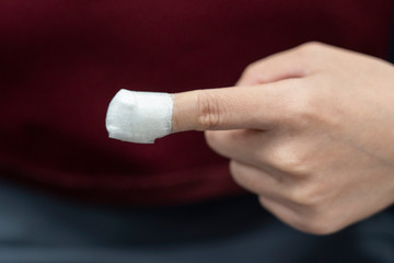 Close-up on woman injured finger with white bandage