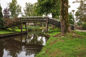 Fototapeta na wymiar Wooden bridges over a canal in Giethoorn