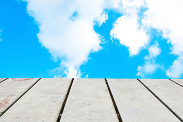 Old Wooden table with blue sky white cloud background.