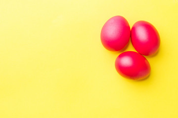 Colorful Easter eggs on yellow background. Copy space.