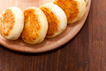 Cheese pancakes on a wooden board, horizontal format view from the top. For menu design and cafe advertising
