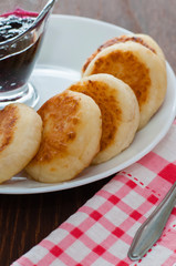 Cheese pancakes with jam, on a white plate, top and side view vertical format