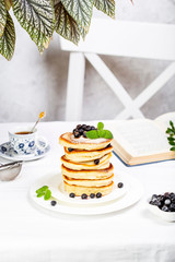 pancake stack decorated with blueberries and powdered sugar