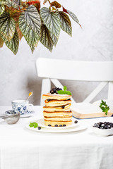 pancake stack decorated with blueberries and powdered sugar