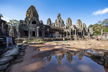 Fototapeta premium Relections of the towers and beautiful face sculptures at the famous Bayon temple in the Angkor Thom temple complex, Siem Reap, Cambodia