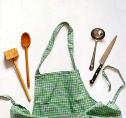 Green checkered apron with kitchen utensils.