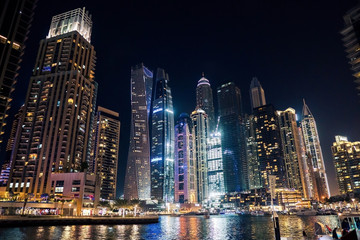 Fototapeta na wymiar Dubai at night. Dubai marina, skylines Dubai Marina. Skyscrapers and Mosque of Dubai Marina in the evening. Ships and boats.