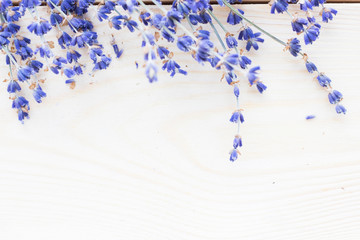 Spa and wellness setting with lavender flowers, sea salt, oil in a bottle, aroma candle on wooden white background