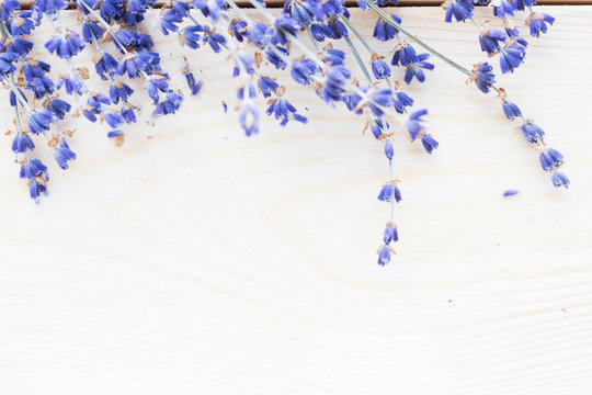 Spa and wellness setting with lavender flowers, sea salt, oil in a bottle, aroma candle on wooden white background