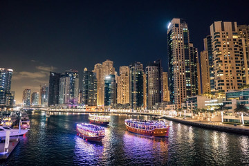 Fototapeta premium Dubai at night. Dubai marina, skylines Dubai Marina. Skyscrapers and Mosque of Dubai Marina in the evening. Ships and boats.