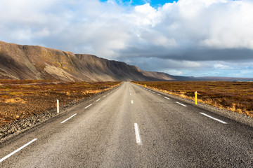 Deserted Road Runnig at the Foot of Beautiful Volcanic Mountainsin  Iceland on a Partly Cloudy Fall Day.