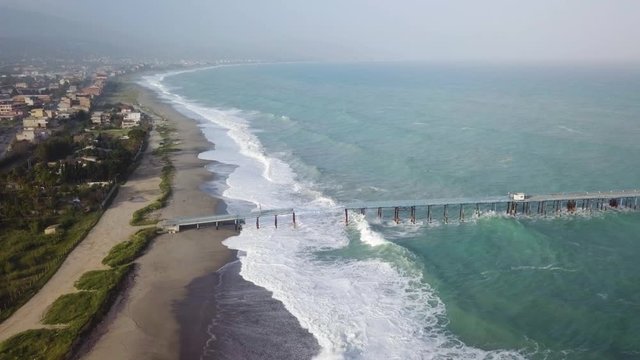 Pontile industriale sull' Oceano distrutto e crollato dalle onde tempestose.
