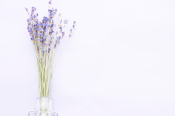 Naklejka premium Spa and wellness setting with lavender flowers, sea salt, oil in a bottle, aroma candle on wooden white background