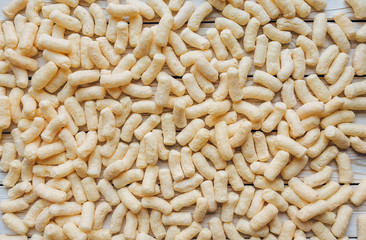 Background of yellow corn sticks. A quick snack concept. The view from the top. Copy space.