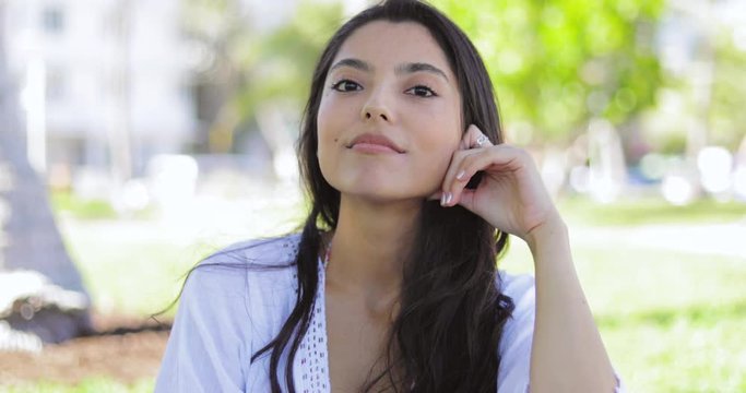 Attractive brunette in summertime looking at camera