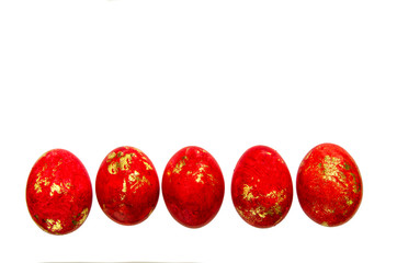 Painted eggs on a white background with a mirror reflection. Five pieces of red color with gold.