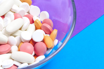 set of multi-colored tablets and capsules on a blue background