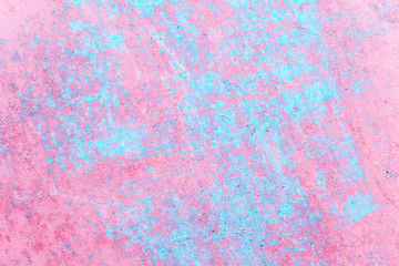 Old rusted metal sheet with peeling off pink and blue textured paint background with copy space
