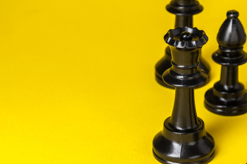 Chess figures on yellow background top view copy space