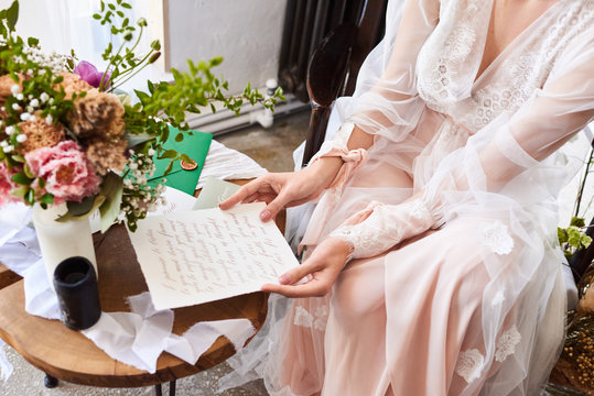 Blurred image in pink beige pastel colors background morning, bride read letter calligraphy. Boudoir photography. Selective focus