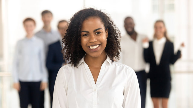 Smiling young mixed-race female worker intern standing looking at camera