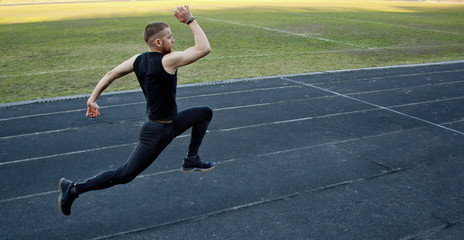 one caucasian male is doing a sprint start. running on the rubber track. Track and field runner in...