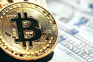 Golden bitcoin coins on a paper dollars money
